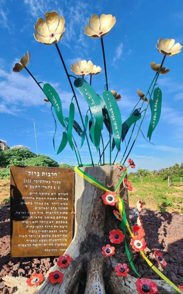 האנדרטה בבית חנן לזכר נופלי נס ציונה: פרחי מתכת זהובים ושלט הנצחה